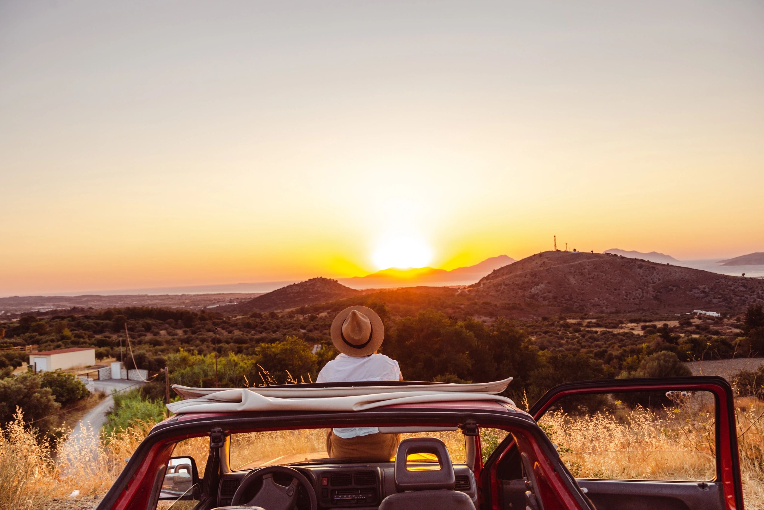 Road trip gear visible in and around a vehicle at sunset