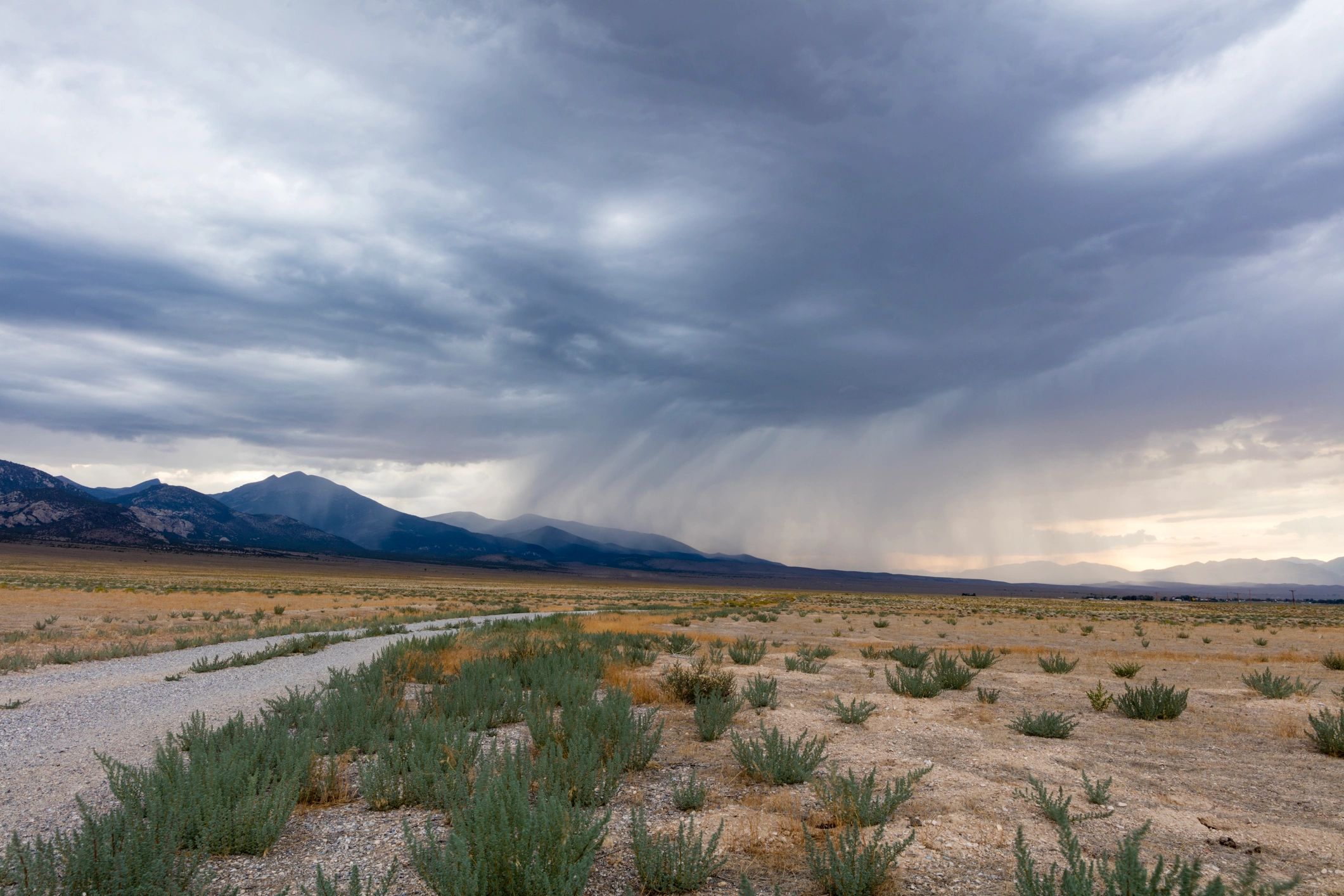 Rainstorm clouds over a mountain range at dusk