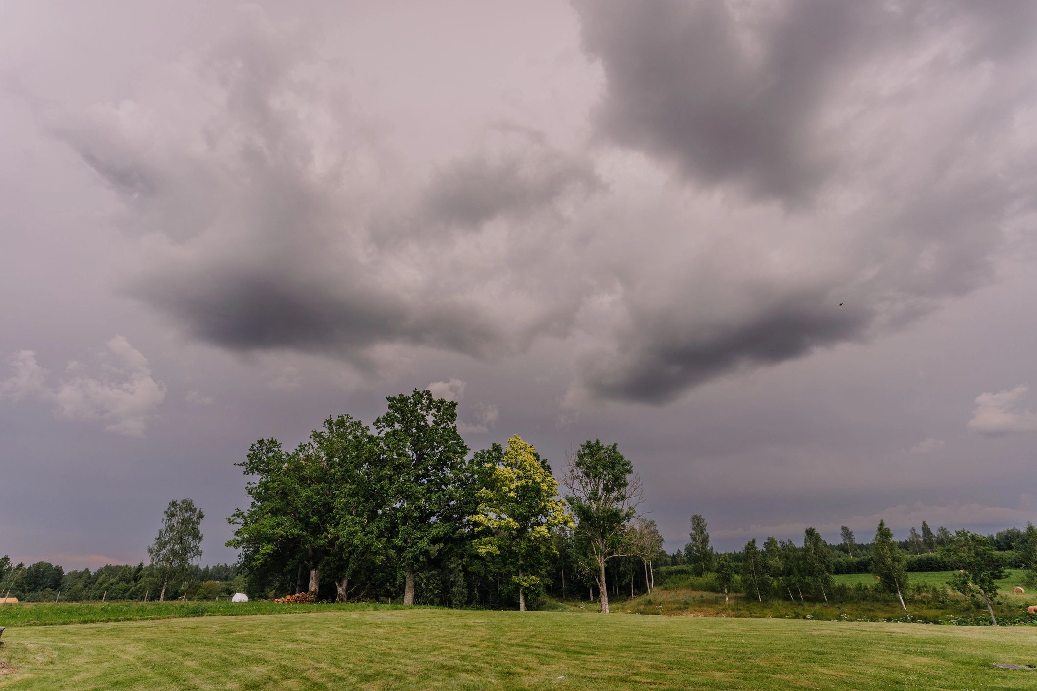 Dark storm clouds gathering over a rural green landscape