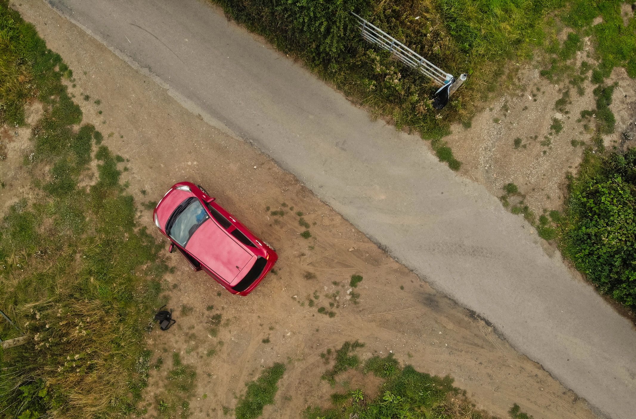 A vehicle on a rural road under dramatic storm clouds