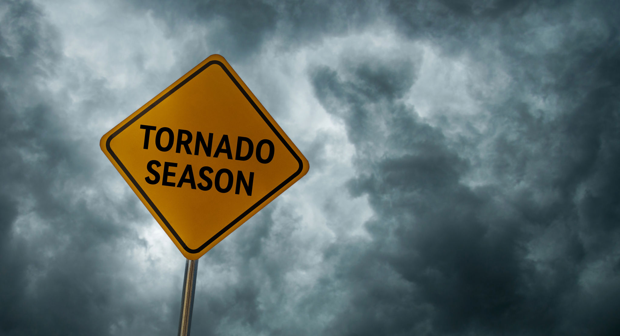 Warning sign under storm clouds representing safety awareness